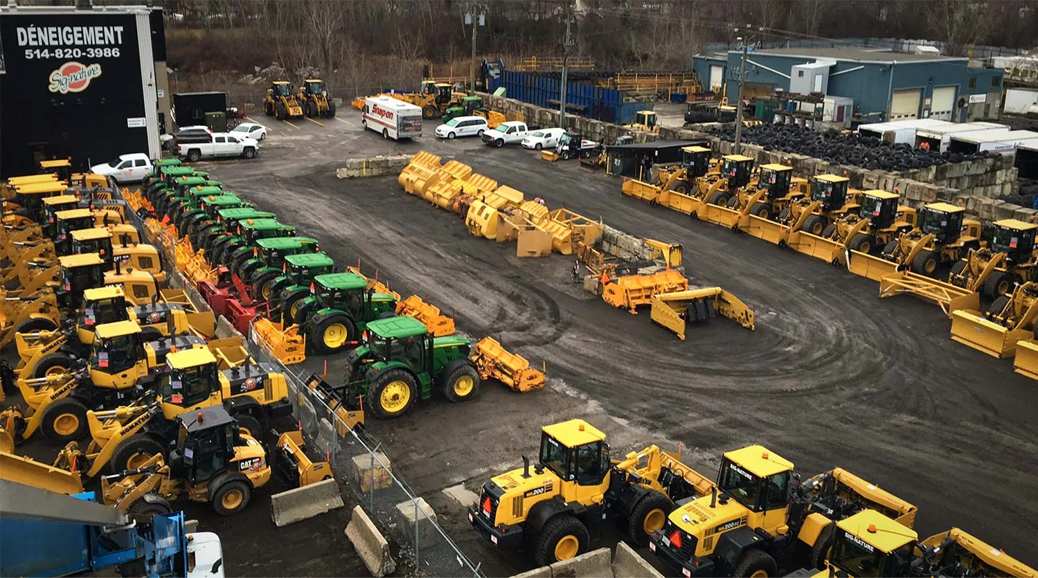 Vue aérienne de la cour Sig-Nature à Laval remplie de chargeurs, tracteurs et charrues